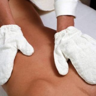 Massage eines Rückens mit einem Rohseidehandschuh
